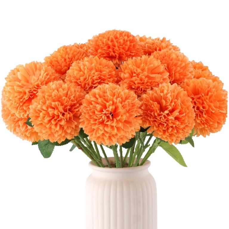 Orange pom-pom flowers in a white vase against a white background