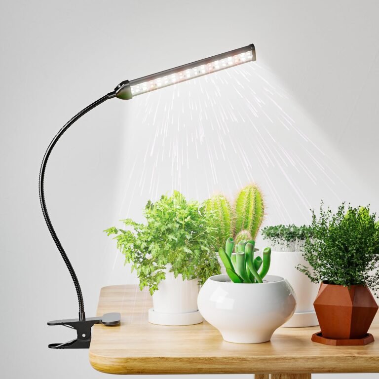 Grow light shining on various potted plants on a wooden table