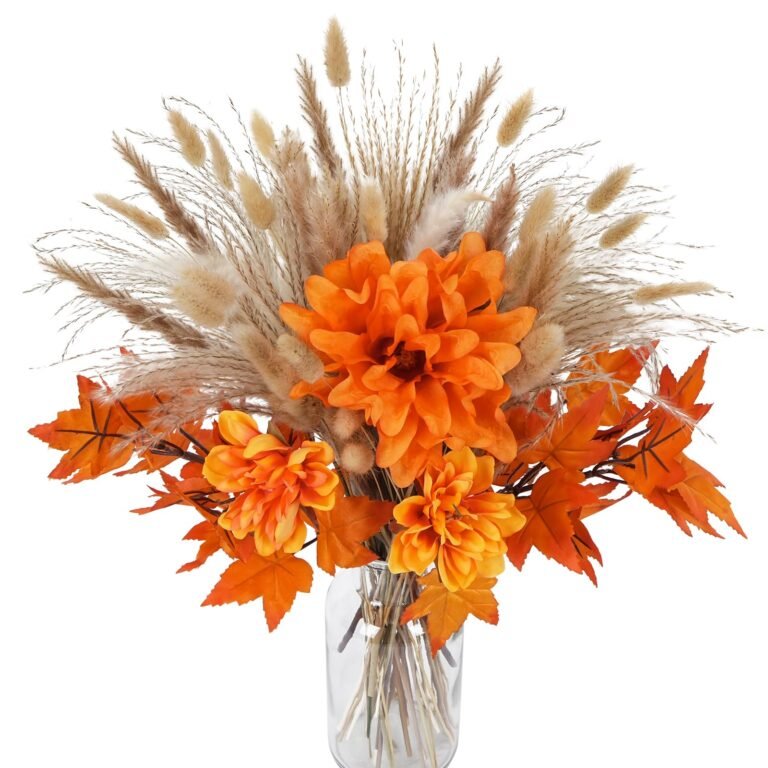 Autumnal bouquet of orange flowers, leaves, and wheat in a glass vase