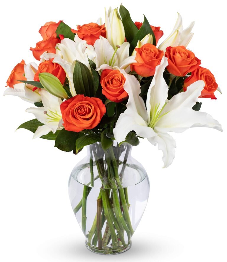 Bouquet of orange roses and white lilies in a clear glass vase
