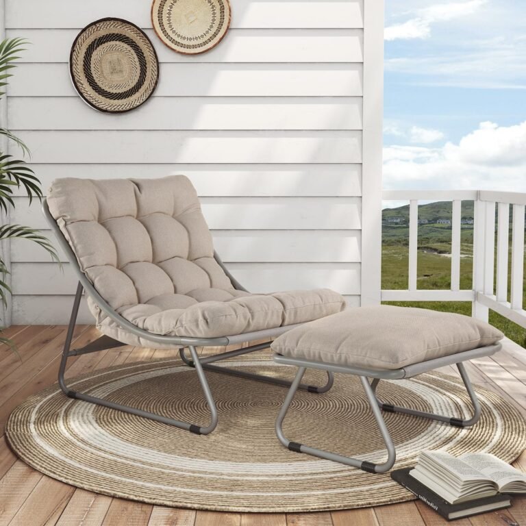 Outdoor chair and ottoman on a porch with a rug and decorative wall art