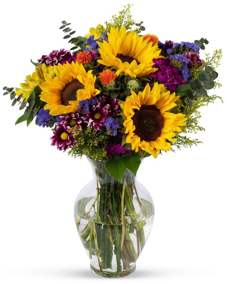 Bouquet of sunflowers and other colorful flowers in a clear glass vase