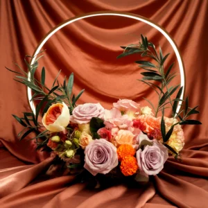 A floral arrangement with roses and greenery inside a glowing circular frame