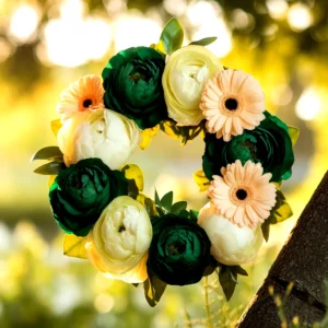A vibrant floral wreath with green, white, and peach flowers, outdoors